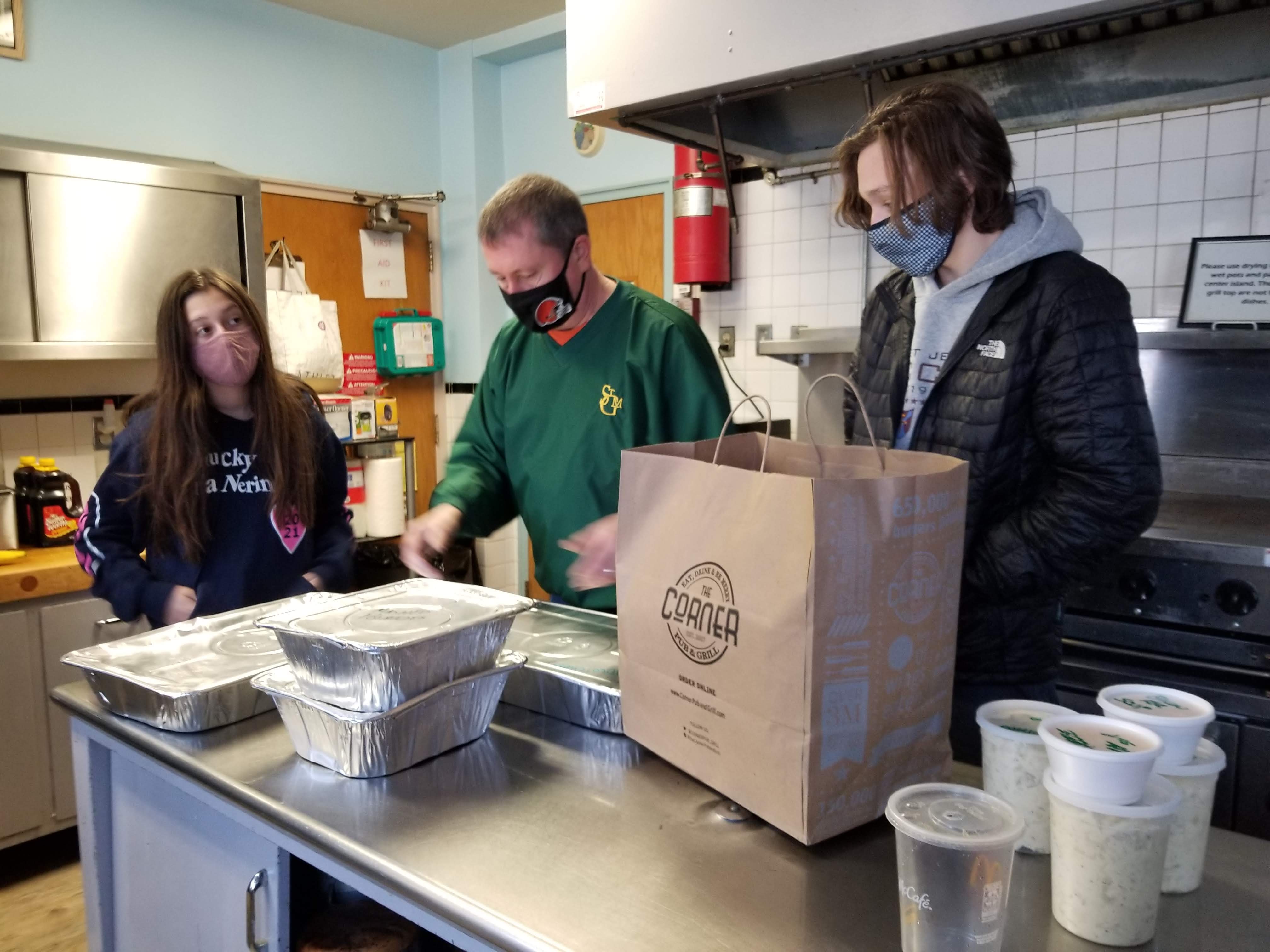 Scott Rockafellow, his daughter, Tess and son, Max, pick up orders that are ready for delivery to three Caritas Connections clients